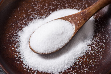 close up of salt in wooden spoon on table