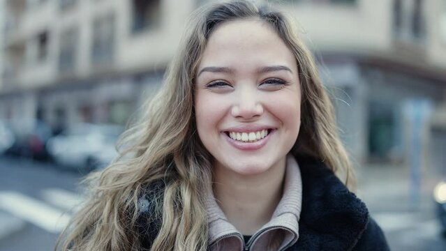 Young beautiful hispanic woman smiling confident standing at street