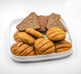 There is grain bread and pumpkin cookies on the plate