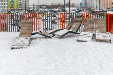 Wooden sun beds are standing in the snow-2