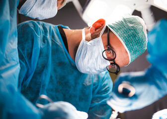 Surgical intern retracting for his boss during a cadaveric lab