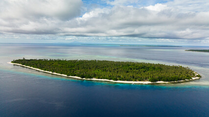 Tropical island in the blue sea with a coral reef and the beach. Balabac, Palawan. Philippines.