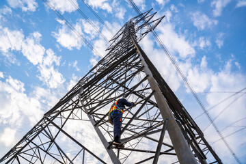 A worker wearing safety suits climb up high-voltage pylons to maintain high-voltage power stations.