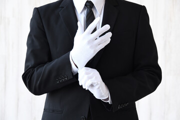 白手袋をはめるスーツを着た男性