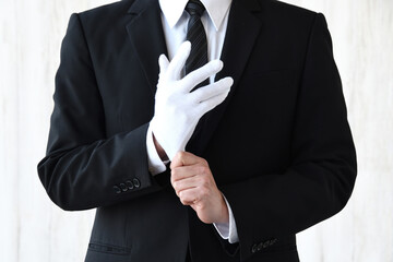 白手袋をはめるスーツを着た男性