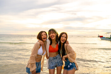 Portrait Group of Young Asian woman friends in walking and playing together on tropical island beach at summer sunset. Attractive girl enjoy and fun outdoor lifestyle travel on beach holiday vacation.