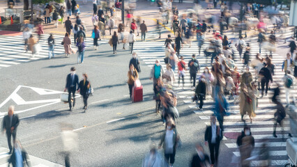 Blurred Crowd of Asian People crossing city street crosswalk with road traffic at Shibuya, Tokyo...