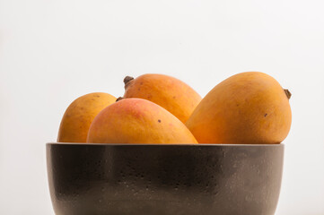 Popular Indian Alfonso mangoes. Whole mangoes placed in a bowl. Fresh Mangoes - a king of fruits.