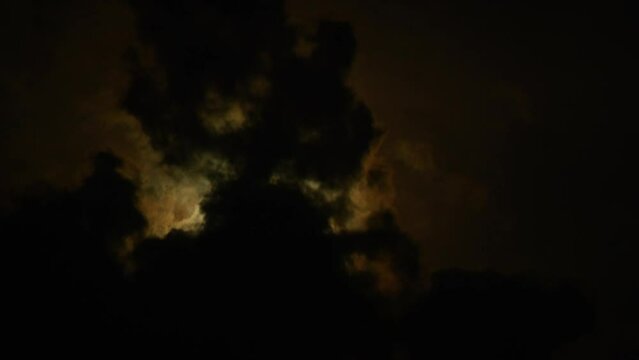 Timelapse of full moon, dark dramatic clouds in night sky, anamorphic time lapse