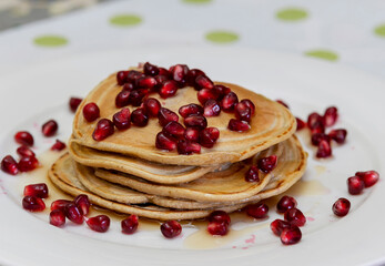 
Oatmeal pancakes with pomegranate, jam and maple syrup.