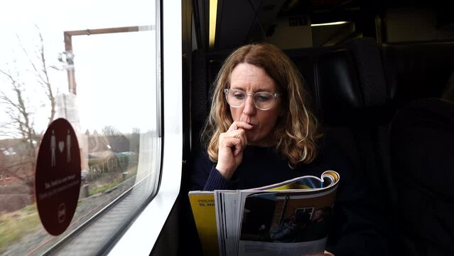 Copenhagen, Denmark A woman passenger on a Danish train sits by the window. 