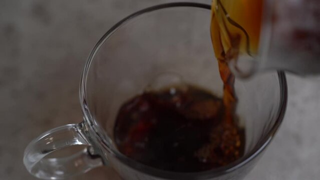透明なカップにコーヒーを注ぐ