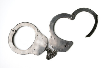 The object is a steel single sided handcuff locked on a white background, symbolizing law, crime and love.