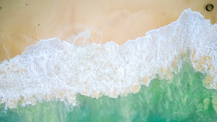 Fototapeta na wymiar Aerial view of the waves splashing to the beach.