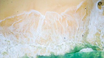 Aerial view of the waves splashing to the beach.