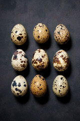 Obraz premium Quail eggs on a black table.