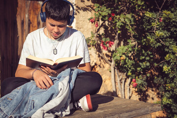 Obraz na płótnie Canvas young man reading a book outside on a sunny day