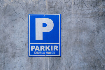 Parking sign for motorbikes nailed on the wall