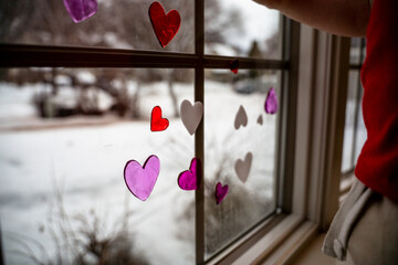 Red White and Pink Heart Window Clings Placed on Window by Toddler