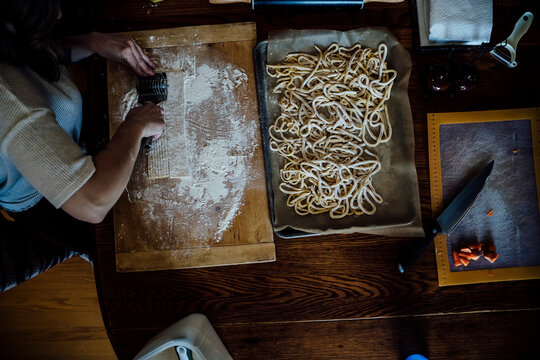 View from Above of Woman Cutting Homemade Pasta on Kitchen Table