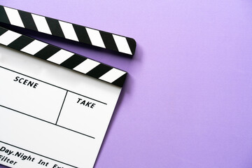 movie clapper on purple table background ; film, cinema and video photography concept