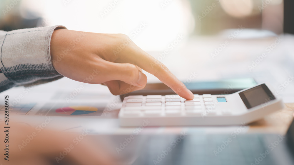 Fototapete accountant calculating figures in company financial documents with a calculator ,analysis of company