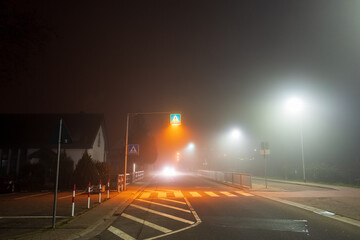 night traffic in the city with thick fog and an approaching car