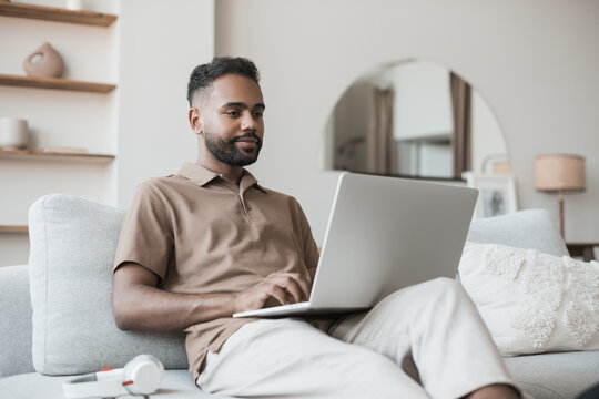 Handsome Young Man Using Laptop Computer At Home. Student Men Resting In His Room. Home Work Or Study, Freelance, Online Learning And Casual Business Concept