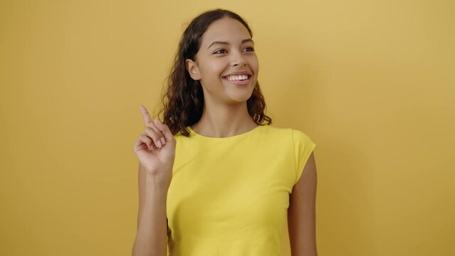 Young african american woman smiling confident doing funny gesture with lips over isolated yellow background