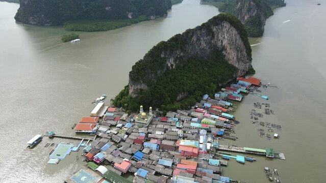 Aerial drone view flying over the floating fishing village at Ko Panyi (or Koh Panyee) one of travel destination in Phang Nga Bay, Phang Nga province, Thailand. 4K footage video