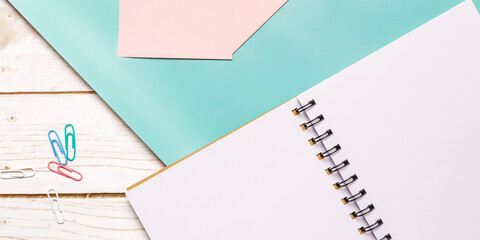 Creative flat lay photo of workspace desk with notebook with empy sheet for copy space, eyeglasses on color background, minimal style