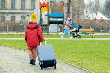 Boy with suitcase went to playground to play. Boy left home..