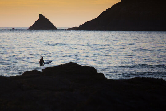 Lone Surfer wating for waves at dusk, Summer, Cornwall,UK