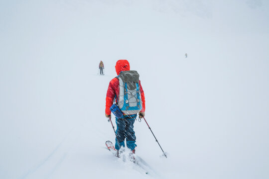 A skier moves quickly as snow falls towards a white horizon during the Spearhead Traverse in the Coast Mountains of British Columbia, Canada.