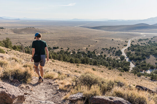 Rear view of a woman hiking above the Hickison Petroglyphs BLM Campground along highway 50 in Nevada.