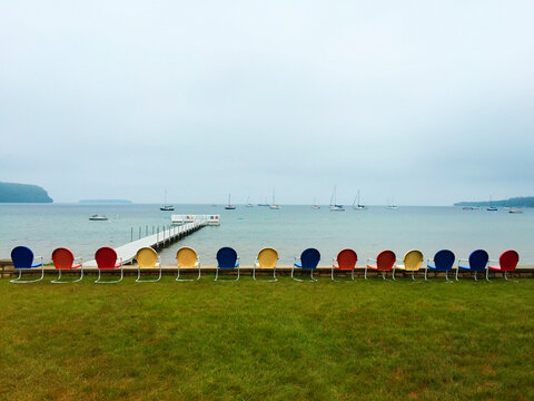 Multi-colored beach chairs sitting along the pier on a cloudy day, Ephraim, Door County, Wisconsin.