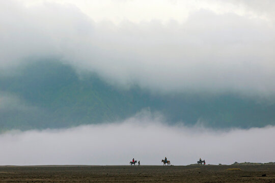 Horse riders near Mt.Bromo in early morning.Java.Indonesia