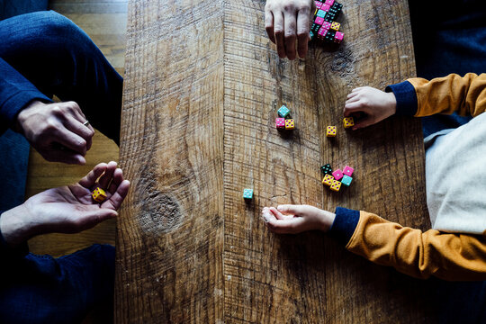 Caucasian Family Playing Colorful Dice Game at Wooden Coffee Table