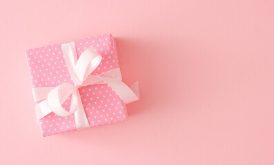 Woman day gift concept. Top view photo of pink present box with silk ribbon bow on pastel pink background with blank space.