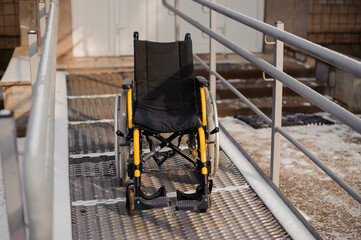 Empty wheelchair in the hospital on the ramp. Wheelchair close-up. Children's wheelchair