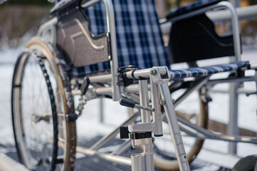 Fototapeta premium Empty wheelchair in the hospital on the ramp. Wheelchair close-up. Children's wheelchair