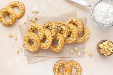 Cookies shortbread rings with peanuts on beige background, top view