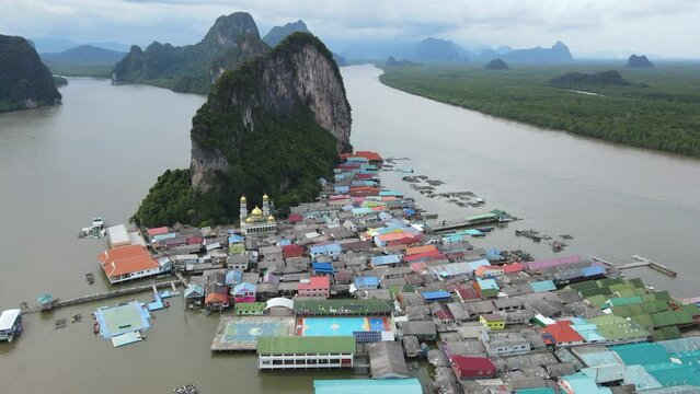 Aerial drone view flying over the floating fishing village at Ko Panyi (or Koh Panyee) one of travel destination in Phang Nga Bay, Phang Nga province, Thailand. 4K footage video