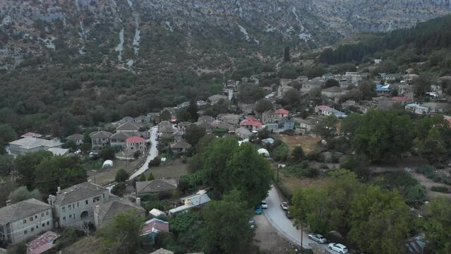 Drone video flying over Tsepelovo old stone Village at Zagori region ioannina Greece panning down looking at the plaza square