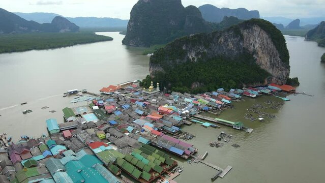 Aerial drone view flying over the floating fishing village at Ko Panyi (or Koh Panyee) one of travel destination in Phang Nga Bay, Phang Nga province, Thailand. 4K footage video