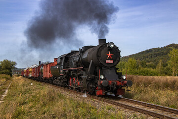 Fototapeta na wymiar a historic set of railway freight cars pulled by a steam locomotive