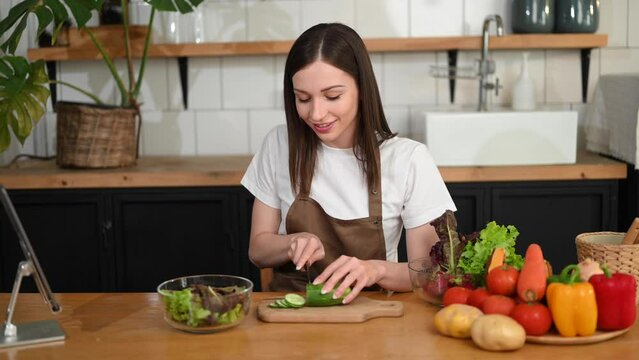 beautiful woman spilling spice onto lettuce serving healthy vegan food in bowl and looking at camera.