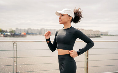 Exercise running female runner trainer training outdoors, in a fitness suit. Smiles and uses smart watches, healthy lifestyle.