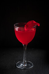 cocktail with rose syrup on dark background