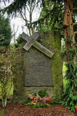 alter Grabstein mit Quer aufgesetztem Kreuz auf einem Friedhof in Velbert